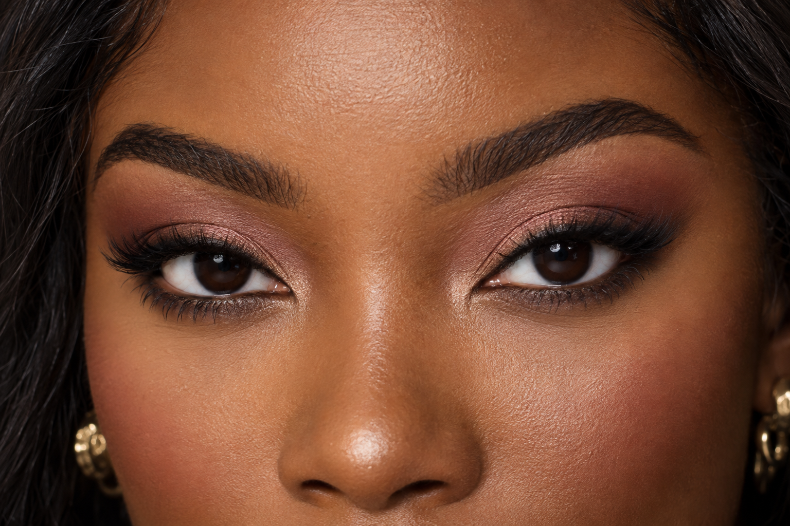 Open hooded eyes with soft rose-brown shadow blended where it stays visible above the fold.
